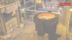 An industrial alumina processing plant facility featuring heavy machinery and storage silos